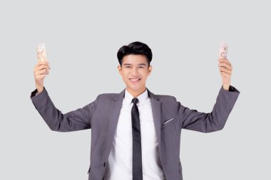 Genç Asyalı iş adamı elinde para tutuyor Taylandlı beyaz arka planda, takım elbiseli iş adamı elinde banknot ve başarı tutuyor ve finans, tasarruf ve yatırım, gelir ve harcamalarla heyecanlanıyor.