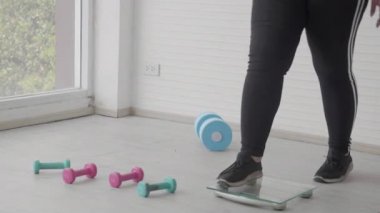 Genç kadın, kilosunu ölçtükten sonra kendini üzgün hissediyor, aşırı kilolu ve endişeli bir kadın, kilo kaybı, boyut, obezite ve kalori, kontrol için diyet.
