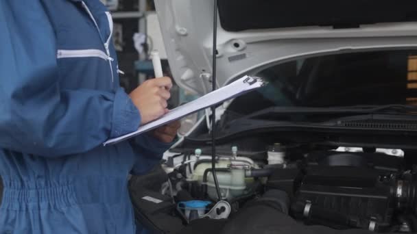 Mechanikerin Mit Klemmbrett Während Sie Den Motor Des Autos Der — Stockvideo