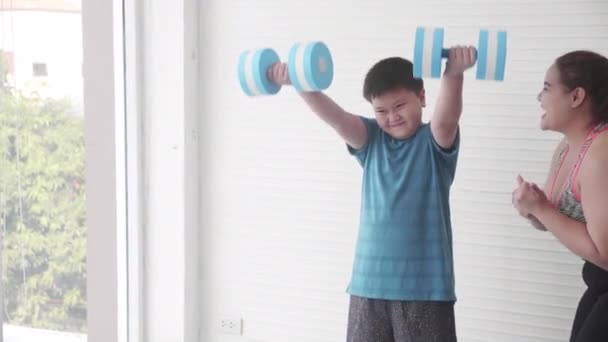 亚洲家庭母亲训练与儿子脂肪运动与哑铃和在家 男孩肥胖运动与伸展和母亲鼓励 加上体形与力量 妇女和儿童超重 — 图库视频影像
