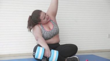 Spor kıyafetlerinde spor yaparken spor kaldırma egzersizi yapan genç Asyalı kadın spor yaparken spor yaparken halterde yoruluyor. Diyet kilo kaybı, beden ve obezite için yorulurken kadın çalışması yapıyor..