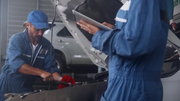 Zespół Mechanika Mężczyzną Mundurze Naprawić Naprawić Samochód Silnikowy Kobieta Trzyma — Wideo stockowe