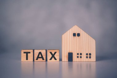 Vergi sözcüğü ve ev modeli ile tahta blok küp, finans, mali planlama, konut ve vergi, bütçe ve vergilendirme hakkında yatırım, iş konsepti hakkında emlak ve mülk.