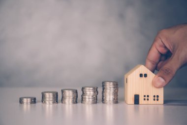 İş adamlarının elleri ve emlak ve başarı, finans ve yatırım, sigorta evi, depozito ve mülk, konut ve finans, iş konsepti için tasarruf edilen para yığını.