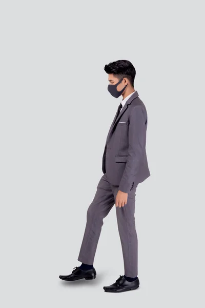 白い背景に隔離された保護Covid 19のための顔マスクの歩行ステップを身に着けているスーツ姿の若いアジアのビジネスマンの肖像画 ビジネスマンと医療 パンデミックコロナウイルスの隔離 新しい通常 — ストック写真