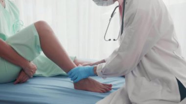 Hastanedeki yaralılar için bacağındaki hastayla bandaj uygulayan doktor, kadın ağrısı ve kemik ayak ağrısı için uzman, teşhis ve hastalık, tıbbi ve sağlık konsepti için tedavi uygulayan doktor.