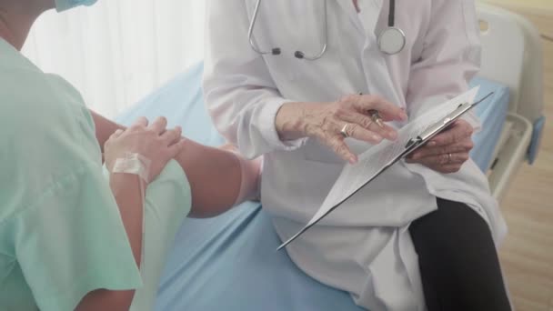 病院の専門医と患者の読書と署名の同意書 診療所で保険のための医師との文書に署名を記入女性 医療と健康の概念 — ストック動画