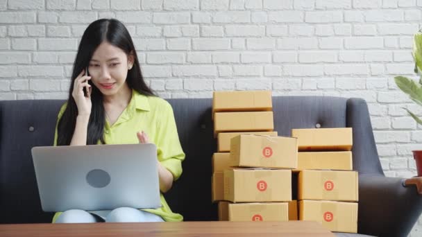 若いアジアの女性は 起業家が顧客と話していると家庭でオンラインで注文を購入しながら ラップトップコンピュータを使用しています 物流と配信 オンラインショッピング 女性はビジネス中小企業の売り手です — ストック動画