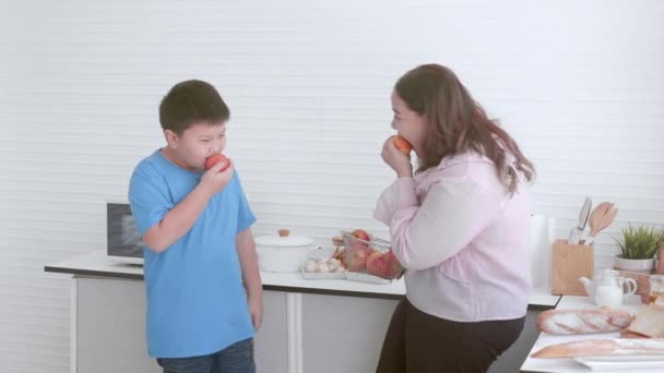 Ung Asiatisk Mor Och Son Fett Stående Äta Äpple Köket — Stockvideo