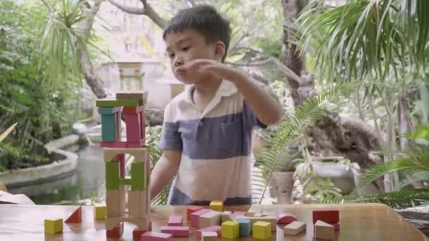 Asiatischer Junge Spielt Holzklötzchenspielzeug Auf Tisch Für Kreativität Und Entwicklung — Stockvideo