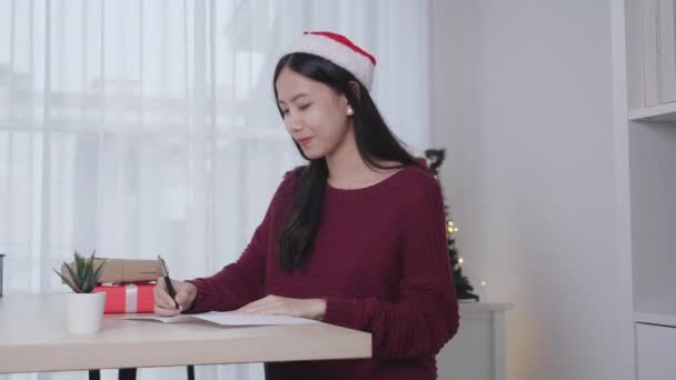 Молода Азіатська Жінка Пише Листівку Різдвяний День Вдома Напередодні Святкування — стокове відео