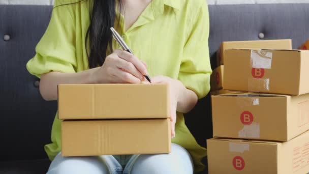 年轻的亚洲妇女在家里的邮筒上写下地址 以便向客户 航运和物流 商人和销售者 店主或中小企业 网上购物等方面下订单 — 图库视频影像