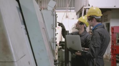 Ekip bakım mühendisi fabrikada birlikte dizüstü bilgisayar kontrol makinesi kullanıyor, endüstriyel ve işletim, insan konuşmaları ve çırak yardımı, işçi çalıştırma, endüstri ve teknoloji konsepti.