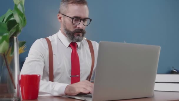 シニアアメリカのビジネスマンフリーランサーは 自宅のオフィスでラップトップコンピュータの仕上げを動作します ビジネスマンは コーヒーを飲み ノートブック上の自宅から仕事 社会的距離 新しい通常 通信の概念 — ストック動画