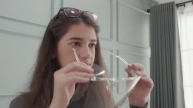 Ofisteki covid-19 salgınında yüzünü korumak için yüz maskesi takan genç Amerikalı iş kadını, yeni normal, sosyal mesafeli, kameraya bakan iş kadını, kadın güvenlik önlemleri.