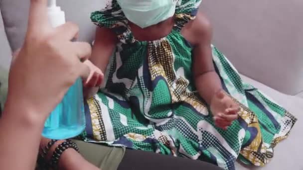 Afrikaanse Moeder Zorg Dochter Dragen Gezichtsmasker Het Gebruik Van Ontsmettingsmiddel — Stockvideo