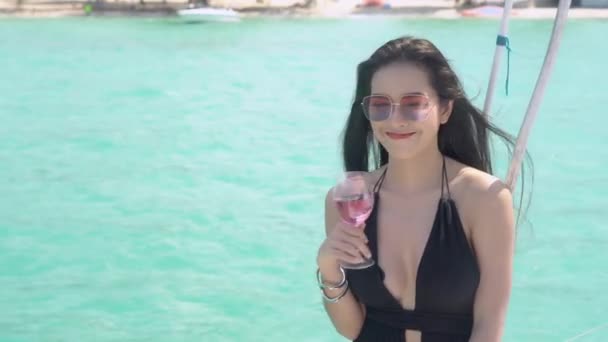 美しい若いアジアの女性はワイングラスを飲み 海辺の休暇でヨットクルーズで楽しむ 海の夏に豪華さで旅行する女の子 休日に幸せな女性はシャンパンを飲む — ストック動画