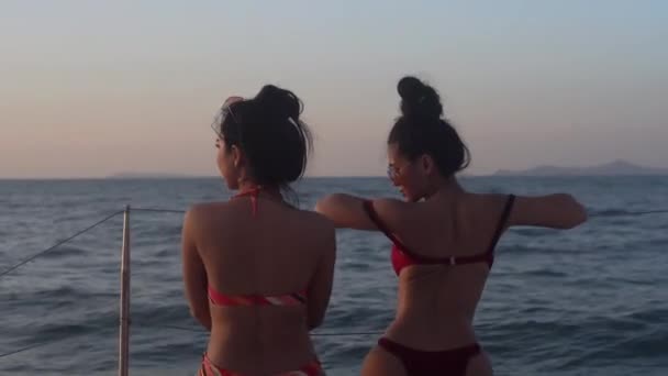 美丽的轮廓两名年轻的亚洲女子性感地在游艇游轮上享受大海中的放松 夏天在度假中旅行 晚上与日落一起在船上度假时快乐地旅行 — 图库视频影像