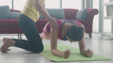 Koç, spor kıyafetlerinde genç Asyalı bir kadını spor yaparken, spor yaparken, birlikte spor yaparken, güçlü ve güçlü vücut kasları ve vücut ağırlığının motivasyonu için, kalas ile kadın antrenmanı yaparken,.