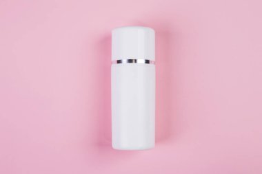 Pembe arka planda izole edilmiş krem ya da losyonlu makyaj şişesi, reklam, cilt bakımı ya da kozmetoloji, üst görünüm, düz döşeme, cilt bakımı ve ürün ile tedavi paketi.