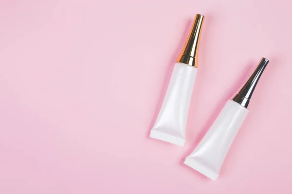 ピンクの背景に単離されたクリームや化粧水とモックアップ化粧品チューブ 広告のためのモックアップパッケージ スキンケアや化粧品 トップビュー フラットレイアウト スキンケアと製品との治療 — ストック写真