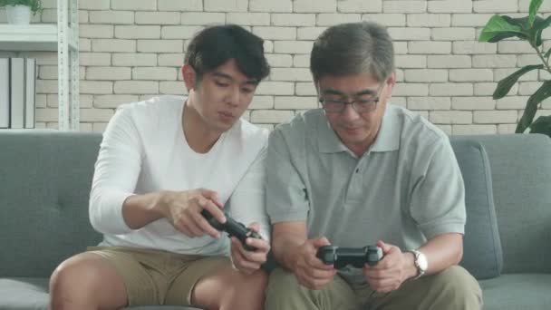 Asian Family Son Teaching Father Play Video Game Sofa Home — Stock Video