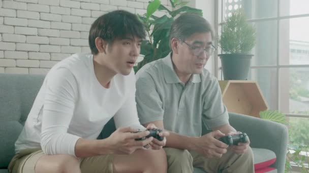 Азиатская Семья Отцом Сыном Играют Видеоигры Диване Дома Пожилые Люди — стоковое видео