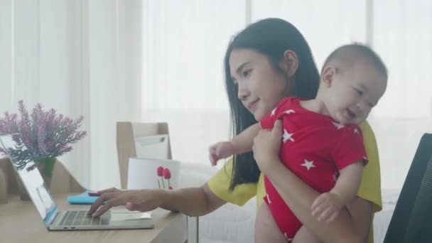 Boldog család anyával terhes baba és dolgozik laptop számítógép az interneten online otthon, anya gazdaság lánya használja notebook szakmai, üzleti és munka otthonról fogalmak.