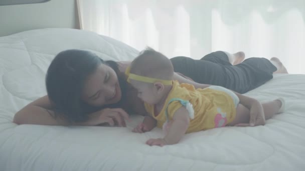 Young Asian Mother Kiss Cheek Little Baby Girl Tender Bed — Stock Video