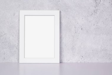 Evdeki masa üstünde ve duvarda dikey beyaz çerçeve, masadaki sunum için poster, galeri fotoğrafı ve resim için tasarım, sınır şablonu ve reklam için dekorasyon.