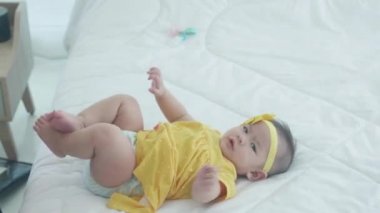 Anne-kız ilişkili mutlu bir aile yatak odasında birlikte eğlenirken, kadın ve yeni doğan yatakta yatarken evde mutlulukla, bebekle ve anneyle ilgilenirken..