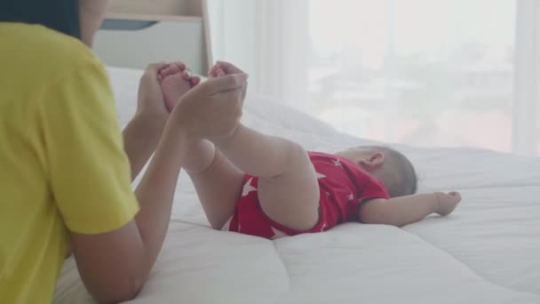 Молода Азіатська Мати Цілує Ногу Маленької Дівчинки Ніжністю Ліжку Спальні — стокове відео