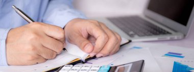 İşadamlarının elleri vergiyi hesap makinesiyle hesaplarken dizüstü bilgisayarlar masanın üzerinde, insan planlama finans ve yatırımı grafik ve grafikle, istatistik ve inceleme hesabı, iş konsepti.