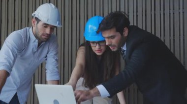 Ekip mühendisi, sistem dizüstü bilgisayarıyla panel güneş hücresini tartışıyor ve inceliyor, mimar grubu, ortakla elektrik ve yenilik, sanayi konsepti hakkında proje planlama kontrolü yapıyor..