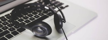 Masada dizüstü bilgisayar ve kulaklık, e-öğrenim çevrimiçi, eğitim ve öğrenim için webinar, not defteri, video konferansı, multimedya için kulaklık, kurs ve internet için sınıf.