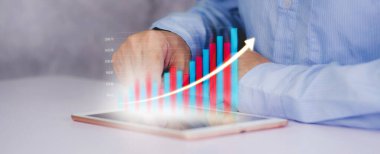 İşadamı tablet bilgisayarına yatırım ve finans grafiği, hisse senedi ve kar büyümesi, dijital pazarlama, finansal ve hedef planlama, iş ve iletişim kavramları ile dokundu.