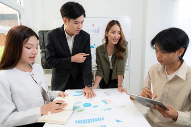 Genç Asyalı iş adamları modern ofisteki projede işbirliği, grup iş adamları pazarlama ve finans planı ve stratejisi için beyin fırtınası yapıyor, girişimin takım çalışması.