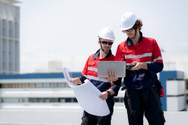 Güneş enerjisi sistemini kontrol eden iki mühendis, kurulum güneş paneli, yenilenebilir enerji ve sürdürülebilir teknoloji, temiz elektrik, sanayi ve güneş hücresi planlama projesini birlikte inceliyor..