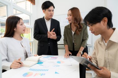 Genç Asyalı iş adamları modern ofisteki projede işbirliği, grup iş adamları pazarlama ve finans planı ve stratejisi için beyin fırtınası yapıyor, girişimin takım çalışması.