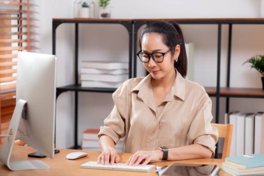 Mutluluk genç iş kadını masaüstü bilgisayarını evdeki oturma odasında kullanıyor, iş kadını internet, girişimci ya da serbest meslek ve iletişim için bilgisayar kullanıyor.