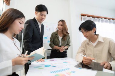 Genç Asyalı iş adamları modern ofisteki projede işbirliği, grup iş adamları pazarlama ve finans planı ve stratejisi için beyin fırtınası yapıyor, girişimin takım çalışması.