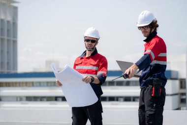 Güneş enerjisi sistemini kontrol eden iki mühendis, kurulum güneş paneli, yenilenebilir enerji ve sürdürülebilir teknoloji, temiz elektrik, sanayi ve güneş hücresi planlama projesini birlikte inceliyor..