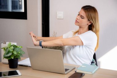 Kafkasyalı genç iş kadını portresi ev ofisindeki kollarını ve ellerini uzatarak çok çalıştıktan sonra dinleniyor. İş kadını ergonomik, iş ve sağlık sorunları ile rahatlıyor..
