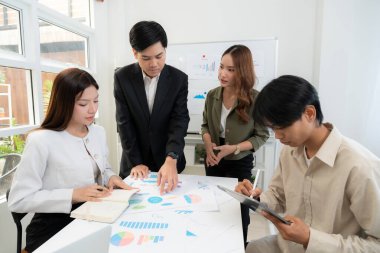 Genç Asyalı iş adamları modern ofisteki projede işbirliği, grup iş adamları pazarlama ve finans planı ve stratejisi için beyin fırtınası yapıyor, girişimin takım çalışması.