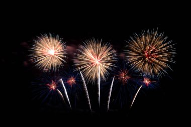 Pek çok renkli havai fişek, siyah arka planla muhteşem bir şekilde yılbaşını, bayramını ve festivalini gece kutluyor..