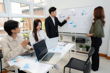 Ofiste planlama ve strateji pazarlaması için grup Asyalı iş adamları toplantısı, grafik ve grafikle finansal veri analizi yaparken, istatistik pazarlamasının sunumu ve açıklaması.
