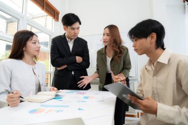 Genç Asyalı iş adamları modern ofisteki projede işbirliği, grup iş adamları pazarlama ve finans planı ve stratejisi için beyin fırtınası yapıyor, girişimin takım çalışması.