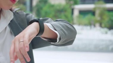 Genç Asyalı iş kadını ses kaydı ya da konuşma tanıma teknolojisini yapay zeka ile ses kumandası için kullanıyor. İş kadını, akıllı adam mikrofonuyla ve ses kayıt cihazıyla konuşuyor..