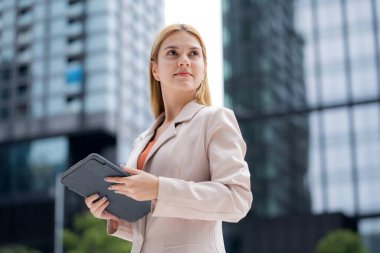 Genç Kafkasyalı iş kadını şehir dışında dijital tablet okuyor, modern teknoloji, iletişim ve kurumsal yaşam tarzıyla çalışan bir yönetici, kentsel şirkette çalışan bir iş kadını..