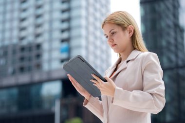 Genç Kafkasyalı iş kadını şehir dışında dijital tablet okuyor, modern teknoloji, iletişim ve kurumsal yaşam tarzıyla çalışan bir yönetici, kentsel şirkette çalışan bir iş kadını..